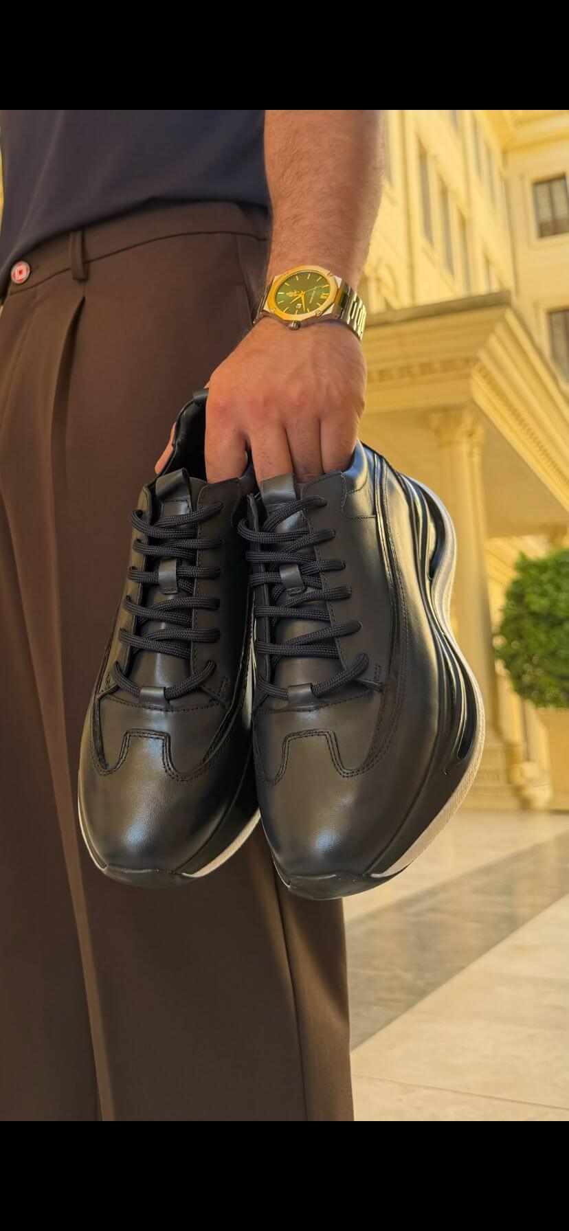 Black leather low-top sneaker for men with clean solid black finish, side view
