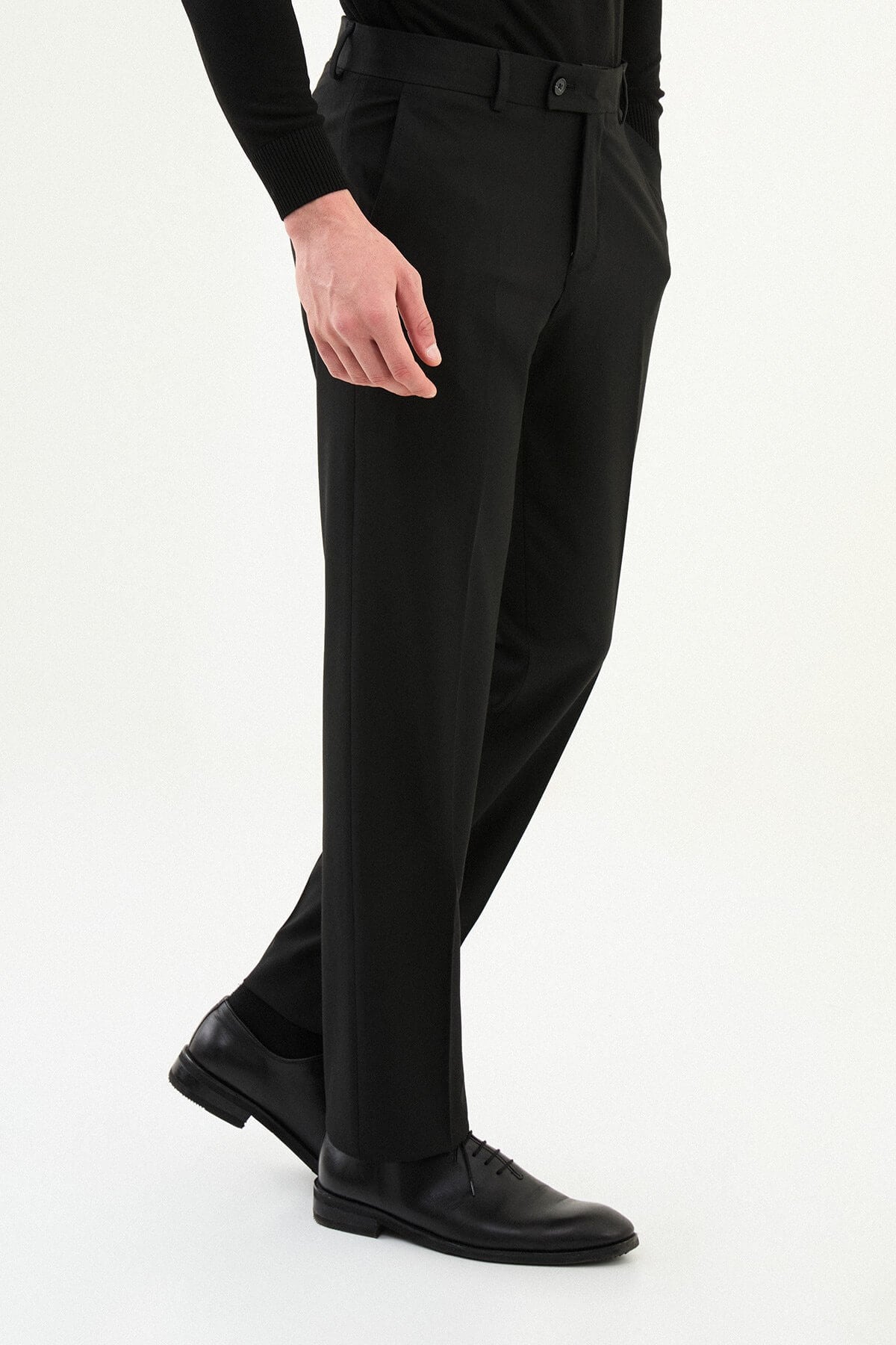 Men wearing black slim-fit classic trousers, styled with formal shoes, suitable for business and formal events.