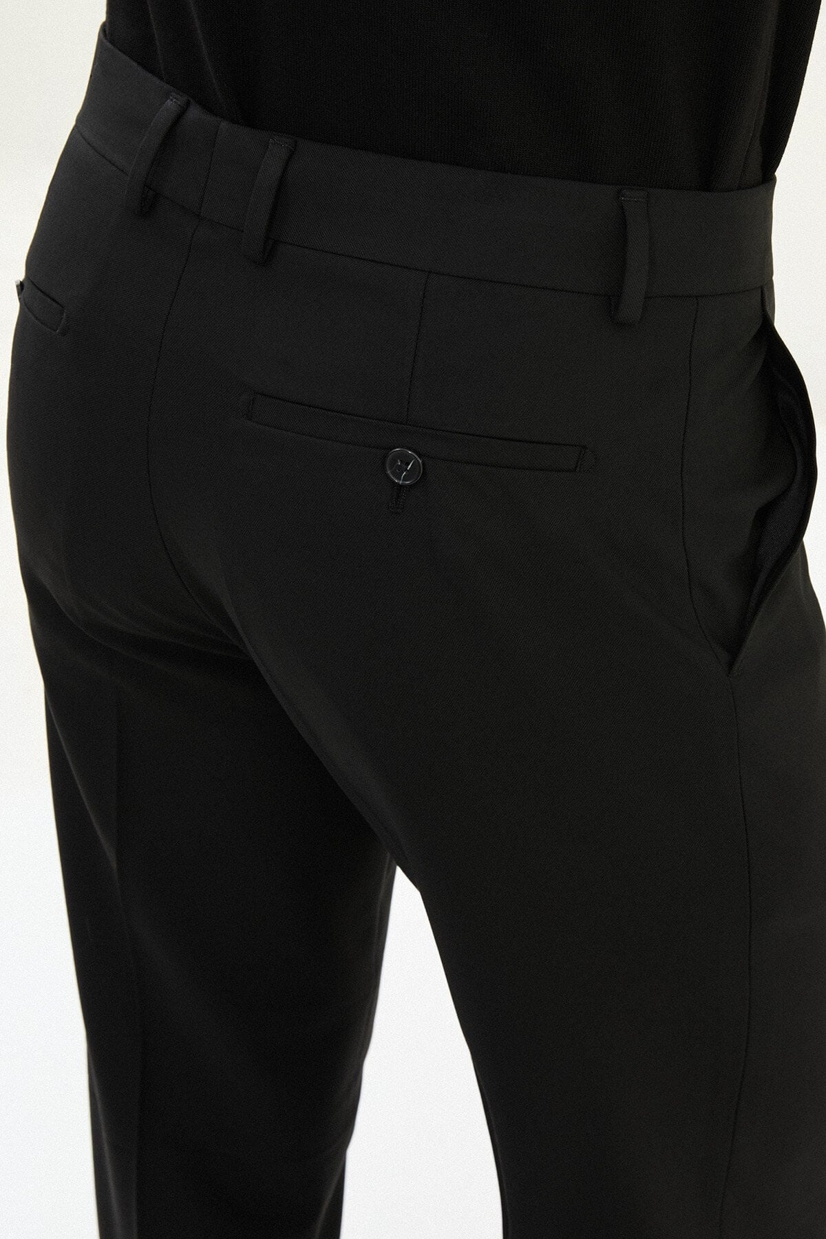 Men wearing black slim-fit classic trousers, styled with formal shoes, suitable for business and formal events.