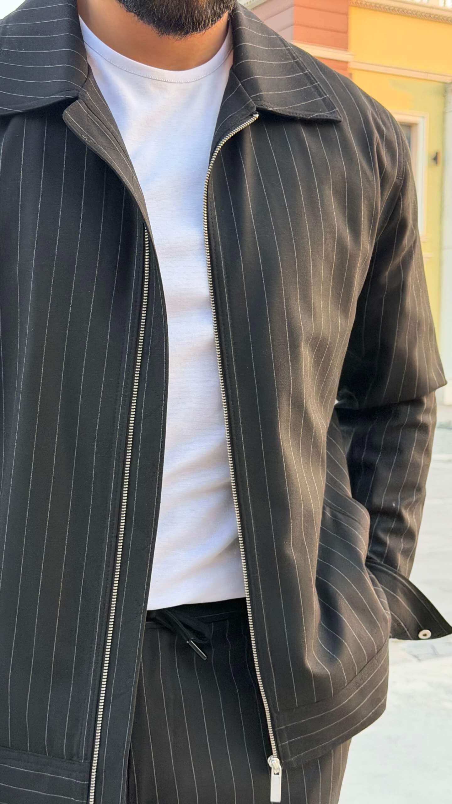 black pinstripe cargo co-set outfit, featuring a zip-front slim-fit jacket with matching cargo pants
