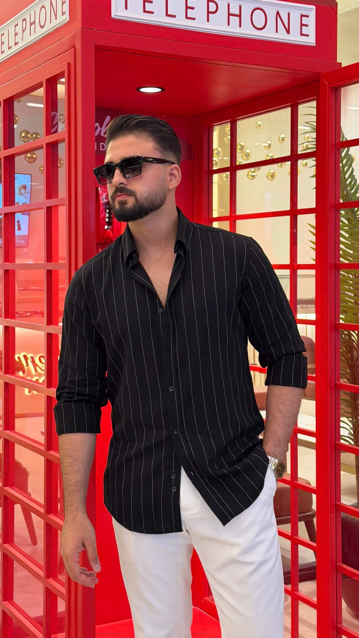 Men’s black pinstripe long sleeve cotton shirt styled with white trousers and black loafers