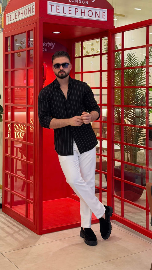 Men’s black pinstripe long sleeve cotton shirt styled with white trousers and black loafers