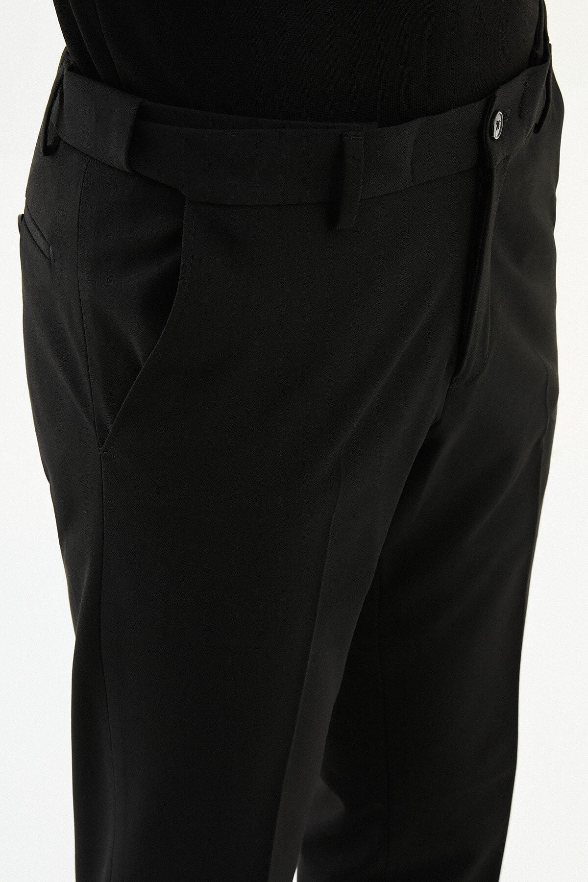 Man wearing black slim-fit formal trousers paired with a black knit shirt and black leather shoes.