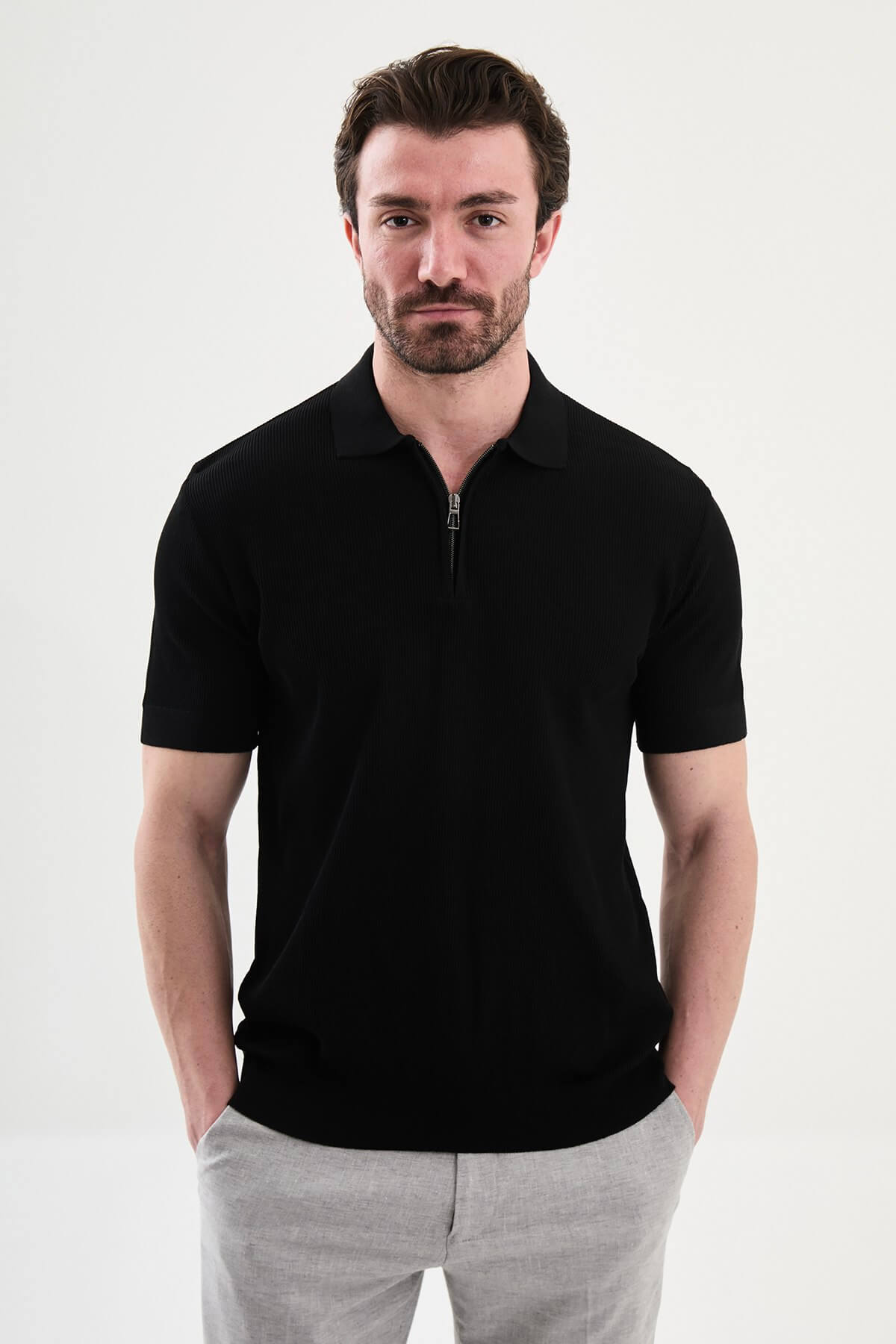 Men’s black slim-fit knit polo shirt with classic collar, short sleeves, and textured knit finish for summer smart-casual style.
