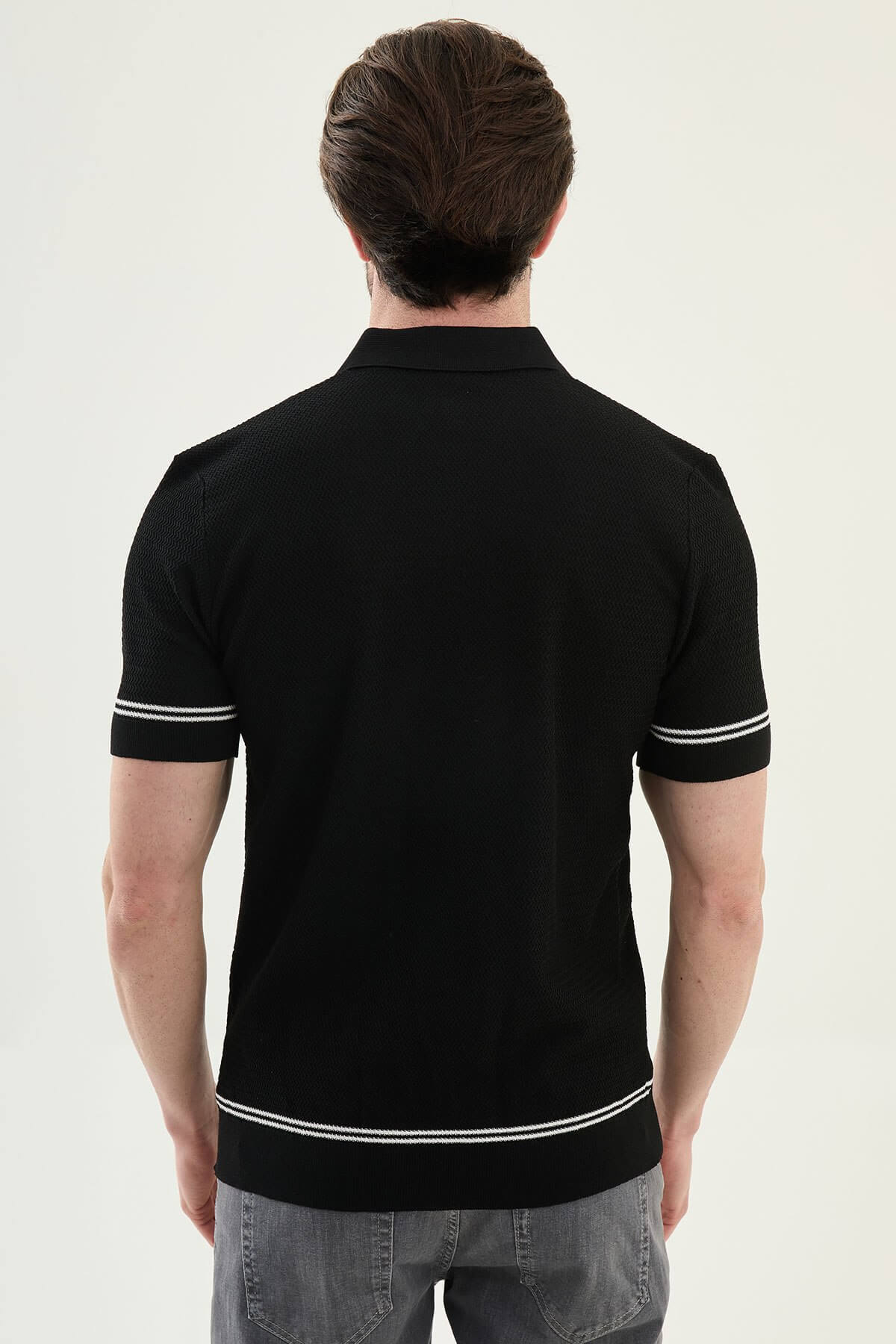 Man wearing a black slim-fit quarter-zip polo T-shirt, short sleeves, styled for summer casual wear, standing against a neutral background.