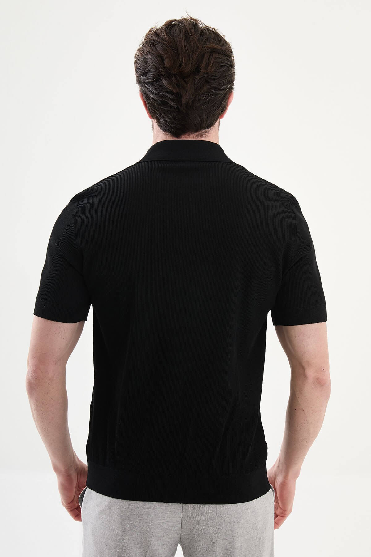 Men’s black slim-fit knit polo shirt with classic collar, short sleeves, and textured knit finish for summer smart-casual style.