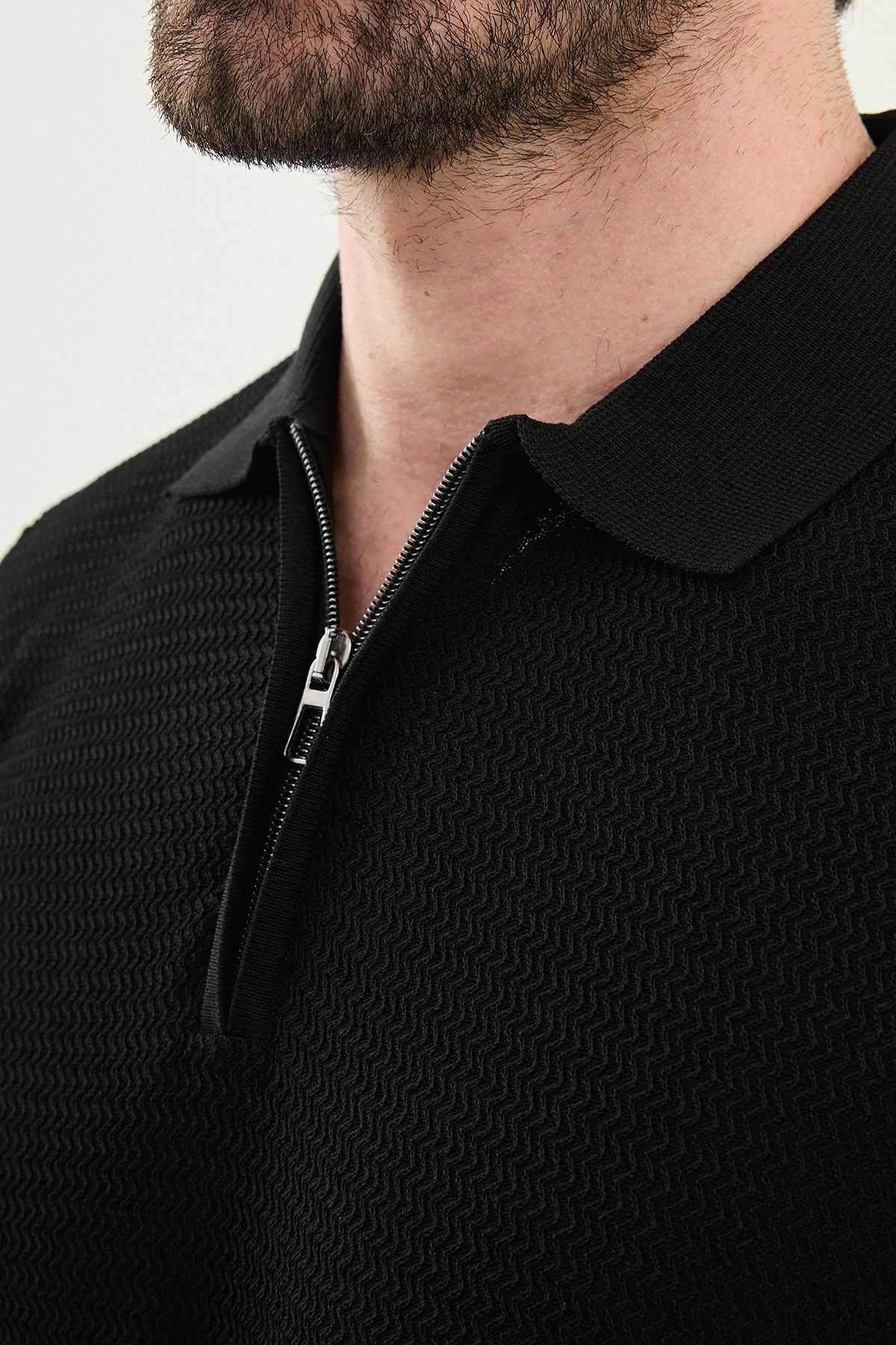 Man wearing a black slim-fit quarter-zip polo T-shirt, short sleeves, styled for summer casual wear, standing against a neutral background.
