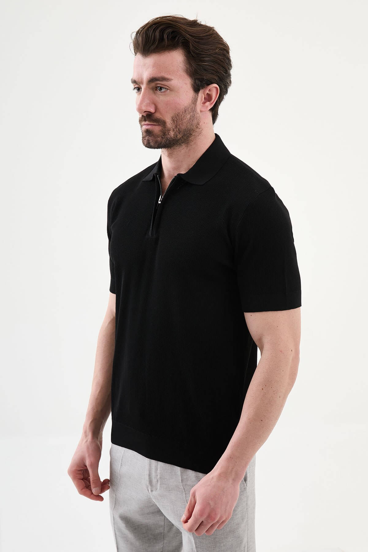 Men’s black slim-fit knit polo shirt with classic collar, short sleeves, and textured knit finish for summer smart-casual style.