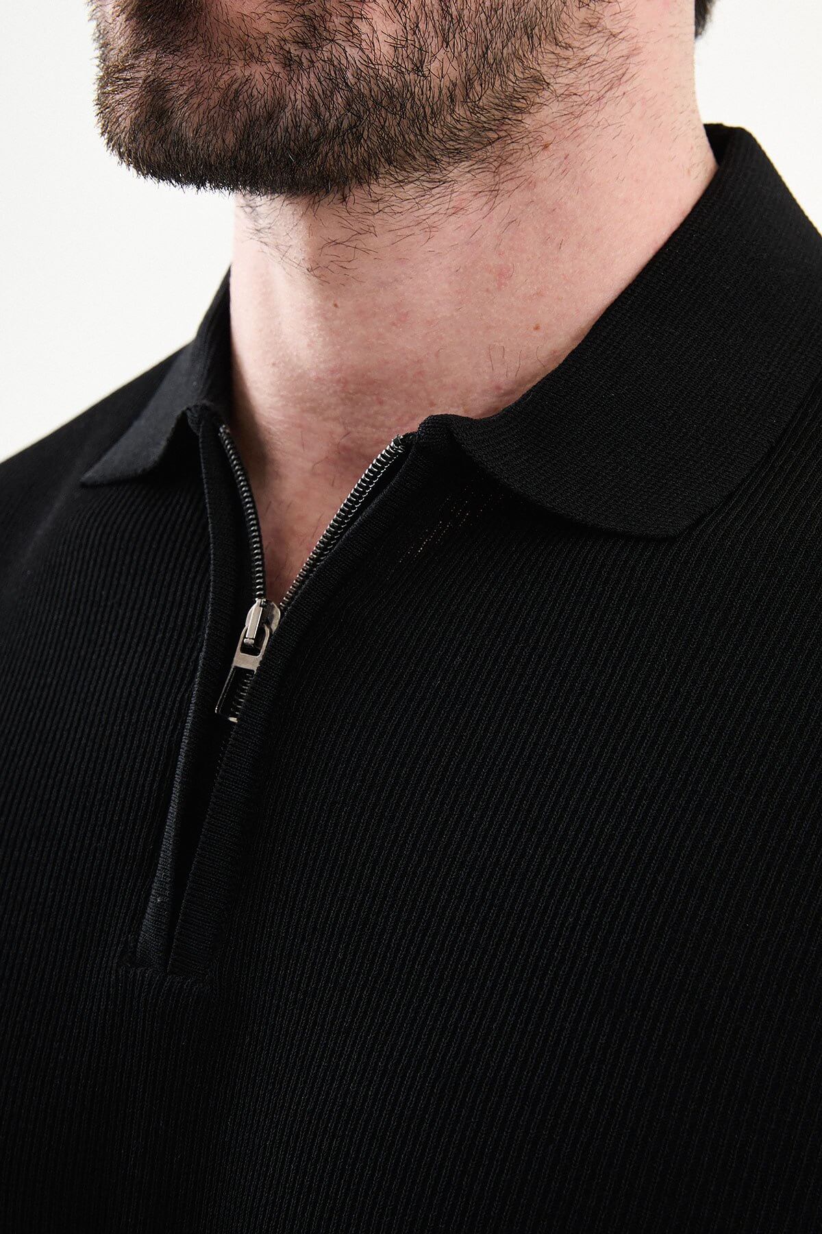 Men’s black slim-fit knit polo shirt with classic collar, short sleeves, and textured knit finish for summer smart-casual style.