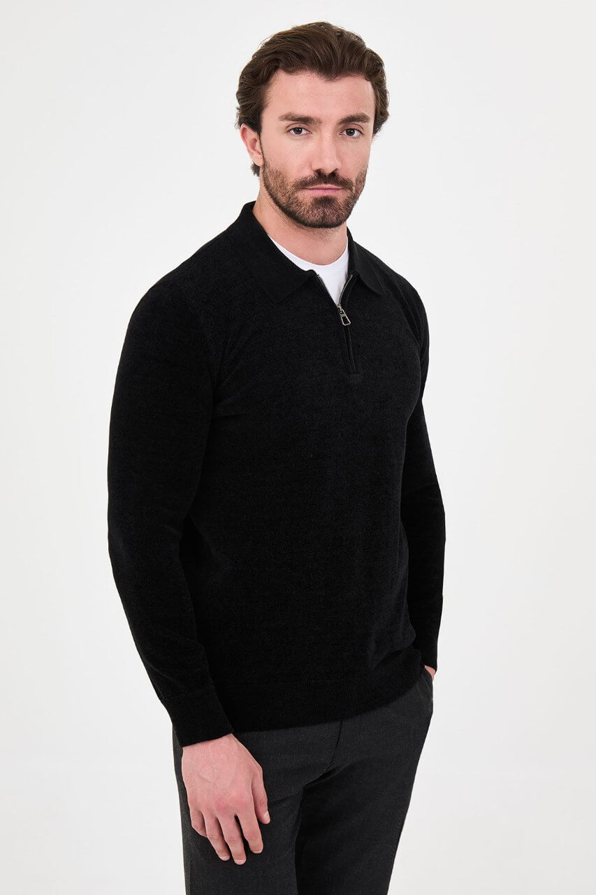 Men’s black polo neck knit sweater with zip collar detail styled with grey trousers for a refined fall winter smart-casual outfit.