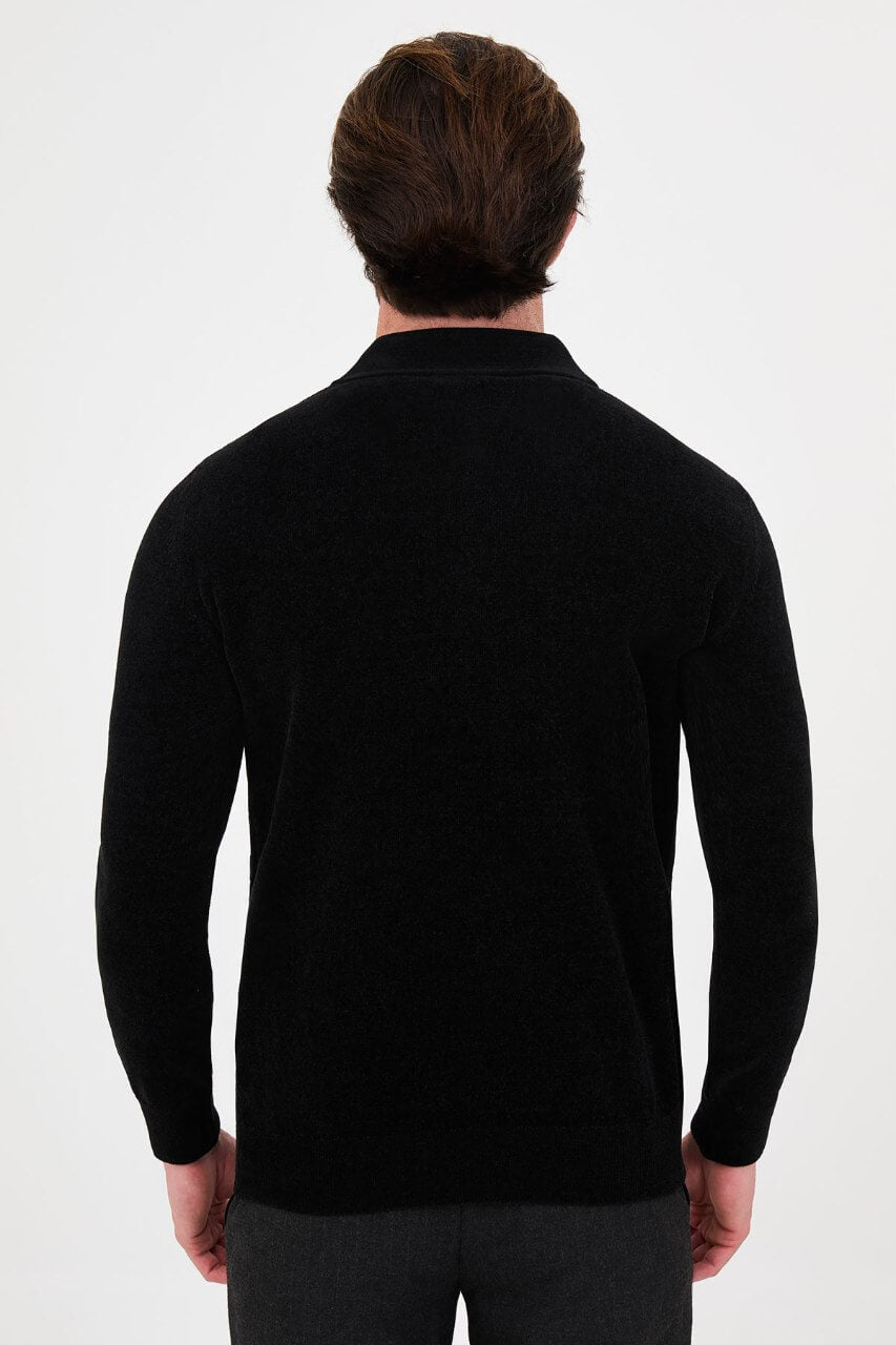 Men’s black polo neck knit sweater with zip collar detail styled with grey trousers for a refined fall winter smart-casual outfit.