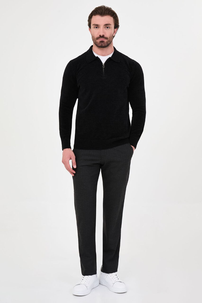 Men’s black polo neck knit sweater with zip collar detail styled with grey trousers for a refined fall winter smart-casual outfit.