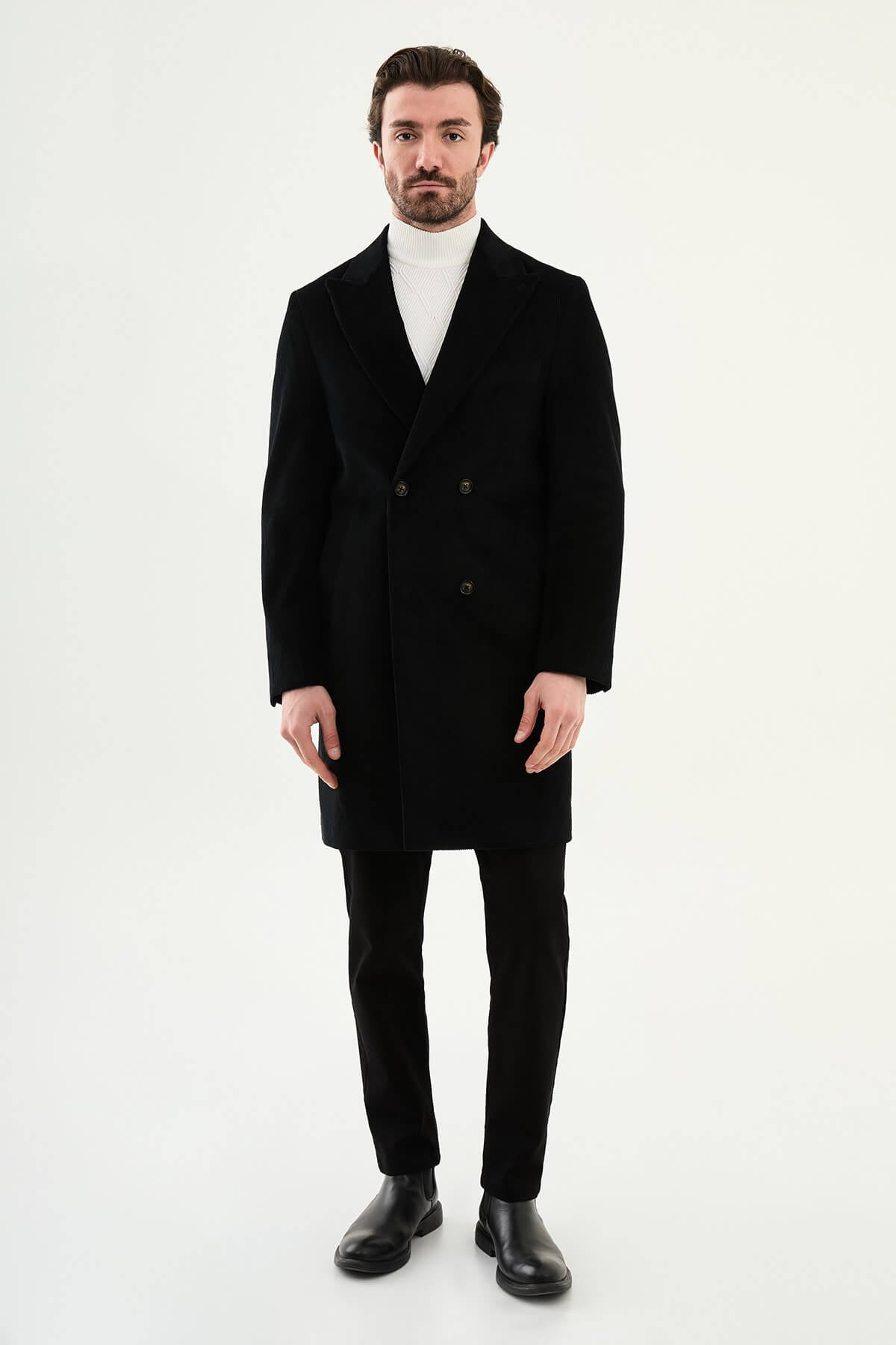 Black double-breasted men’s coat styled with white turtleneck sweater
