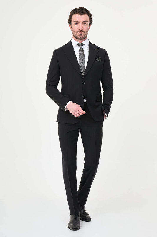 Man wearing a black slim fit wide collar premium wool suit with a patterned tie and pocket square