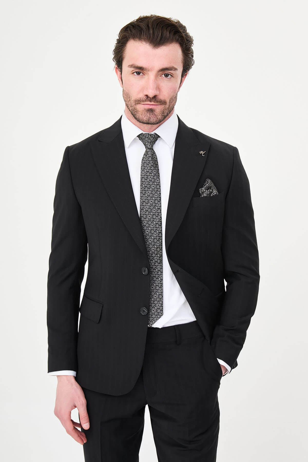 Man wearing a black slim fit wide collar premium wool suit with a patterned tie and pocket square