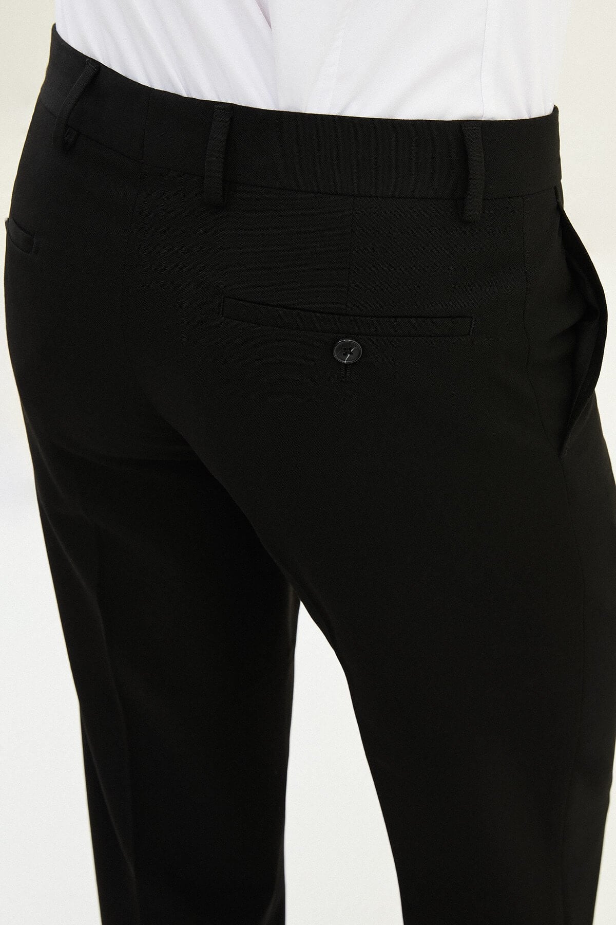 Black slim-fit formal trousers with front pleats, styled with black leather shoes.
