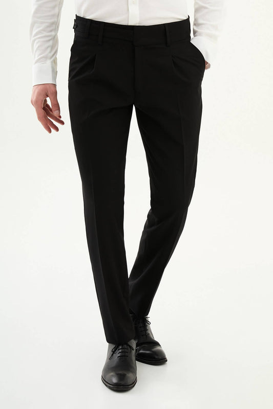 Man wearing black slim-fit straight-leg pleated trousers styled with a white dress shirt and black leather shoes, ideal for summer formal and business occasions.