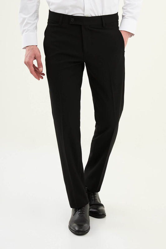 Man wearing black slim-fit dress trousers styled with a white shirt and black leather shoes.