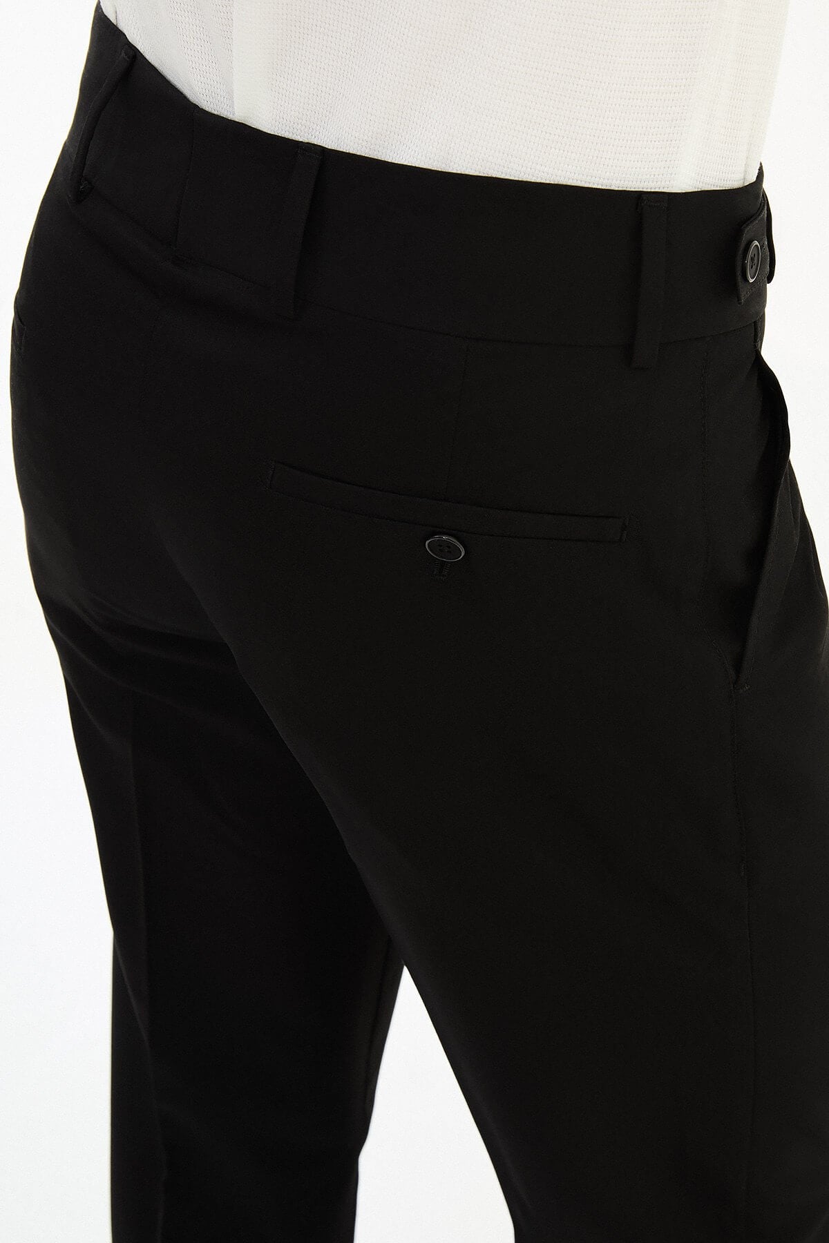 Man wearing black slim-fit straight-leg pleated trousers styled with a white dress shirt and black leather shoes, ideal for summer formal and business occasions.