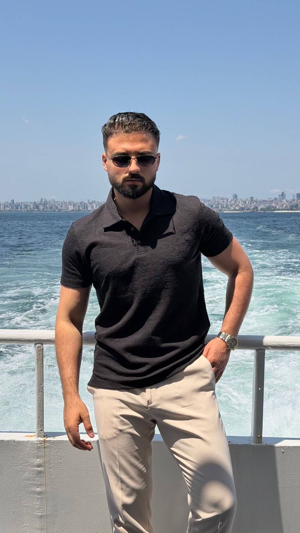 Men’s black textured knit polo shirt with short sleeves and modern smart casual design
