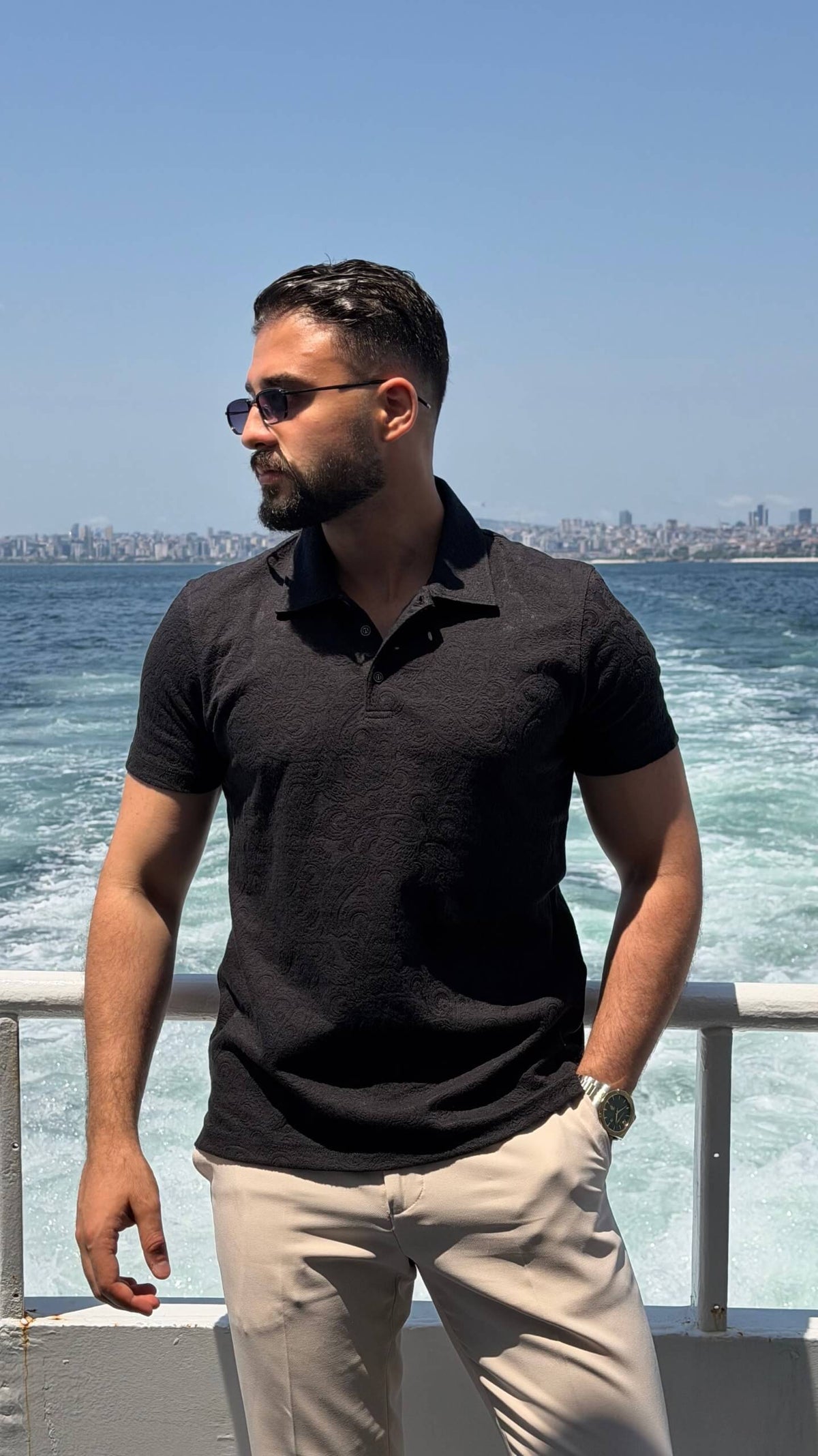Men’s black textured knit polo shirt with short sleeves and modern smart casual design