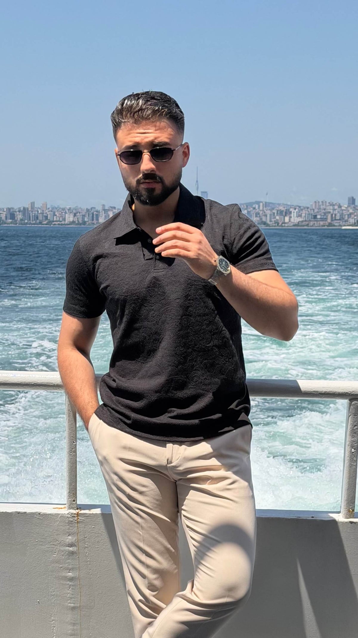 Men’s black textured knit polo shirt with short sleeves and modern smart casual design