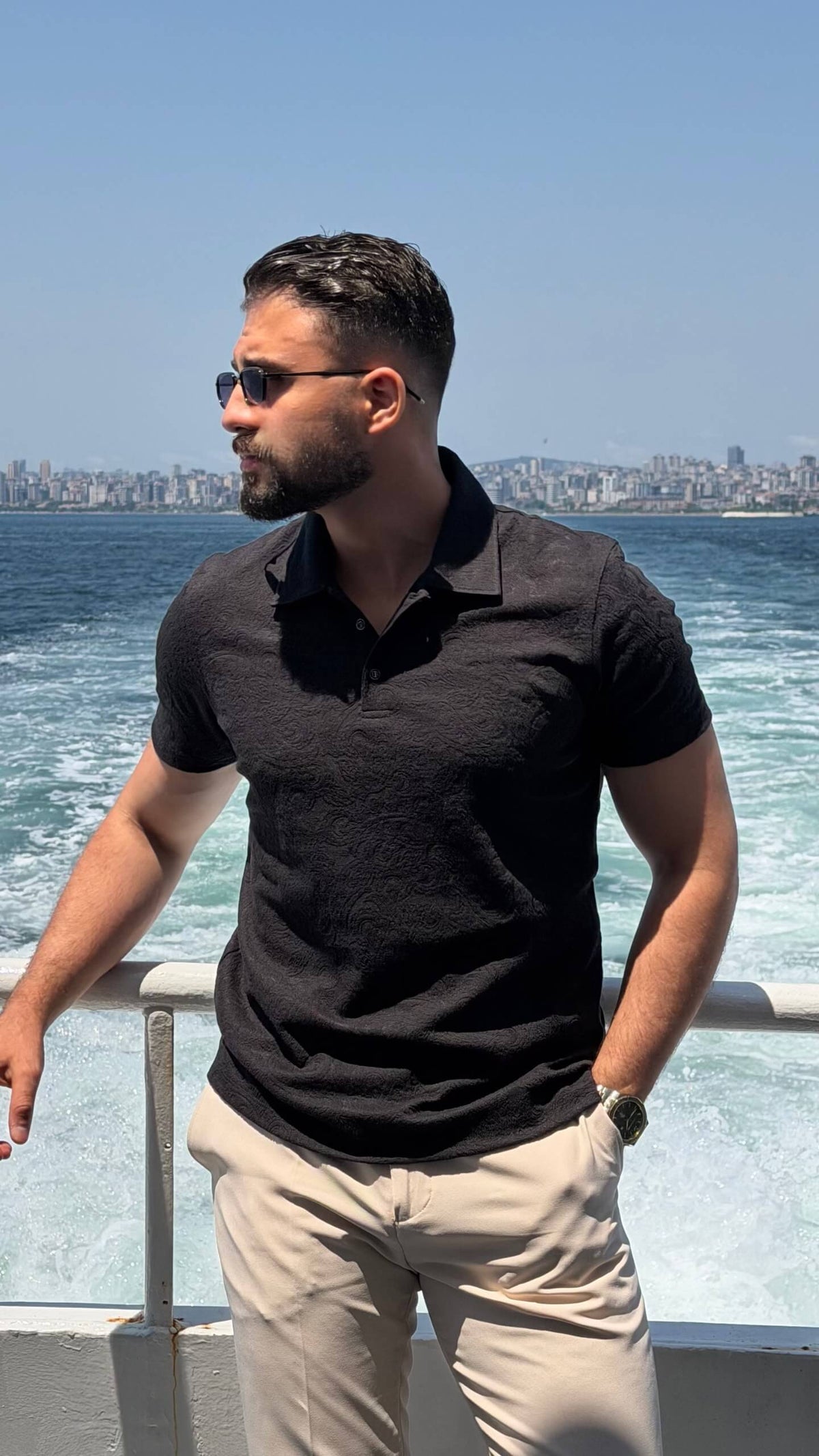 Men’s black textured knit polo shirt with short sleeves and modern smart casual design