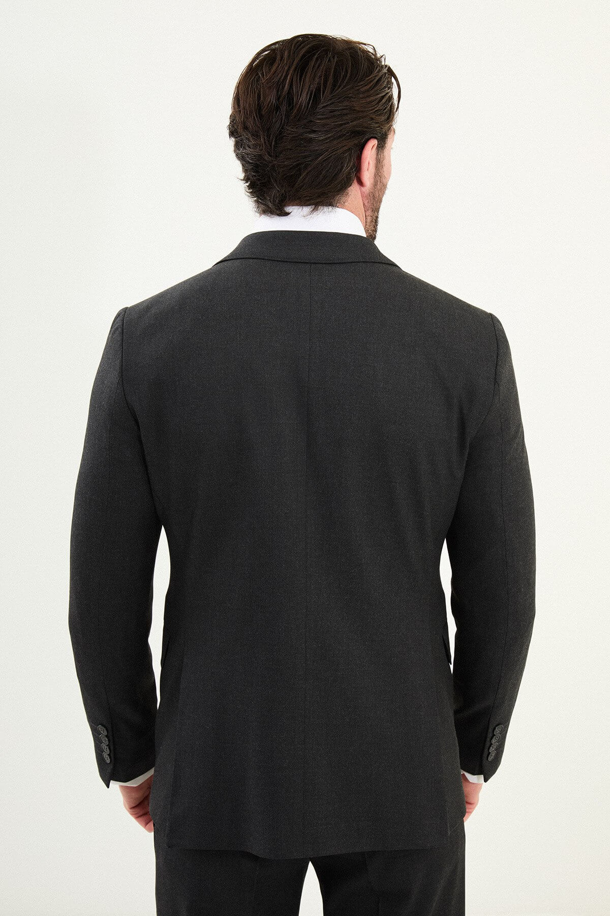 Men’s matte black slim-fit three-piece wool-blend suit with single-breasted jacket, V-neck waistcoat, slim tapered trousers, tonal buttons, and origami lapel pin.