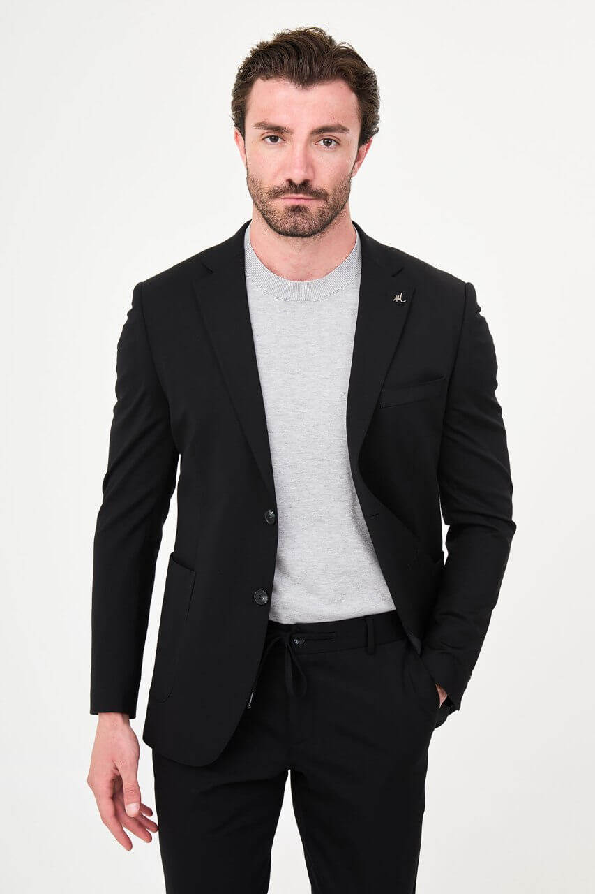 Men's black slim-fit casual suit with a two-button blazer, notch lapels and front patch pockets.