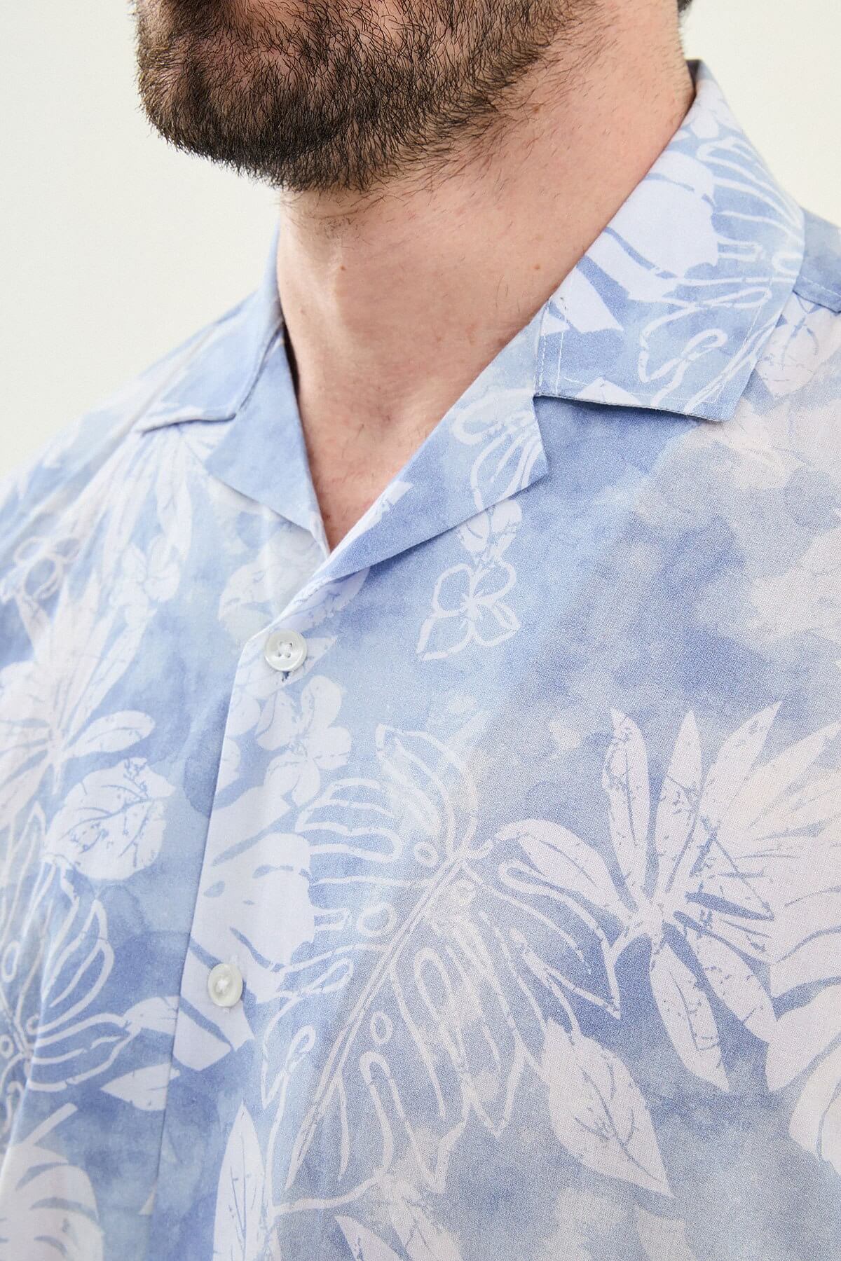 Men’s blue tropical print short sleeve shirt crafted from lightweight 100% cotton, designed for relaxed summer and resort wear styling.