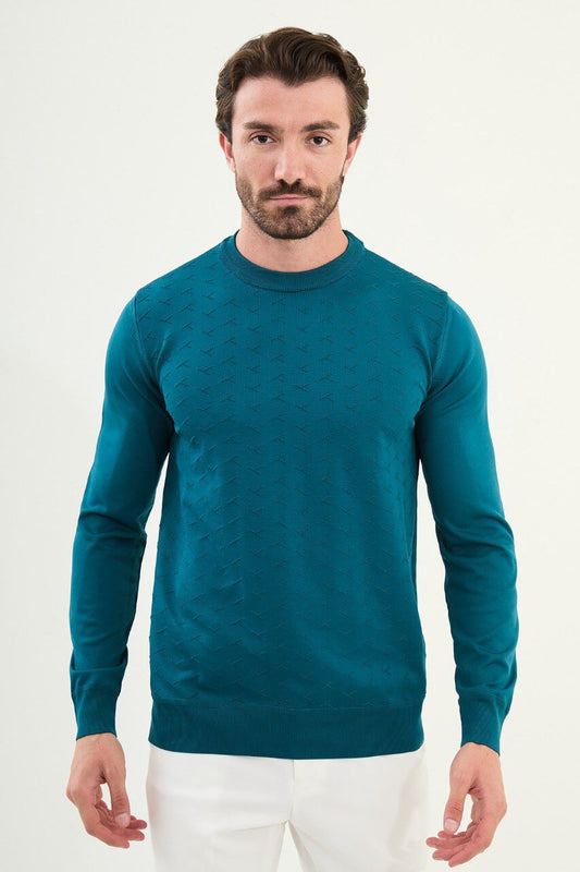 Men’s teal-blue slim-fit crew-neck sweater with geometric ‘T’ textured knit front panel, cotton-viscose-elastane blend, styled with white trousers.