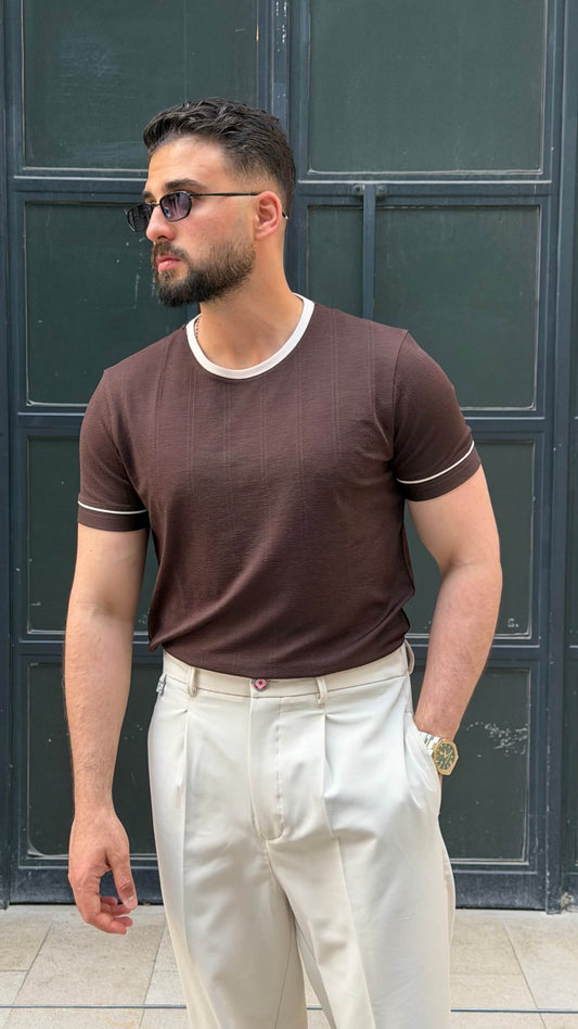 brown crew neck T-shirt with subtle texture, worn by a male model, paired with cream trousers, showcasing a slim fit and short sleeves.