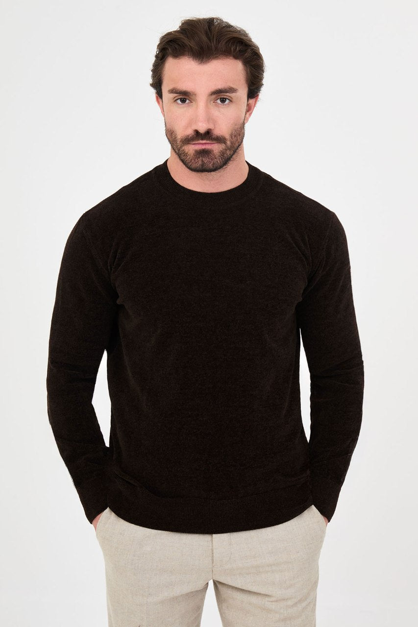 Men’s brown crew neck knit sweater in a cotton blend slim fit design styled with beige trousers for a refined fall winter outfit.