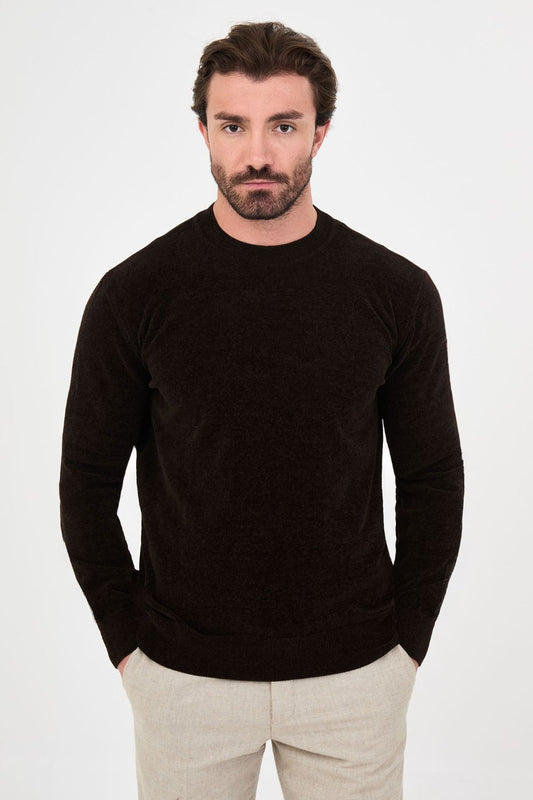 Men’s brown crew neck knit sweater in a cotton blend slim fit design styled with beige trousers for a refined fall winter outfit.