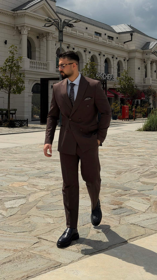 Men wearing a brown double-breasted slim-fit two-piece suit standing outdoors, styled with black shoes and a tie.