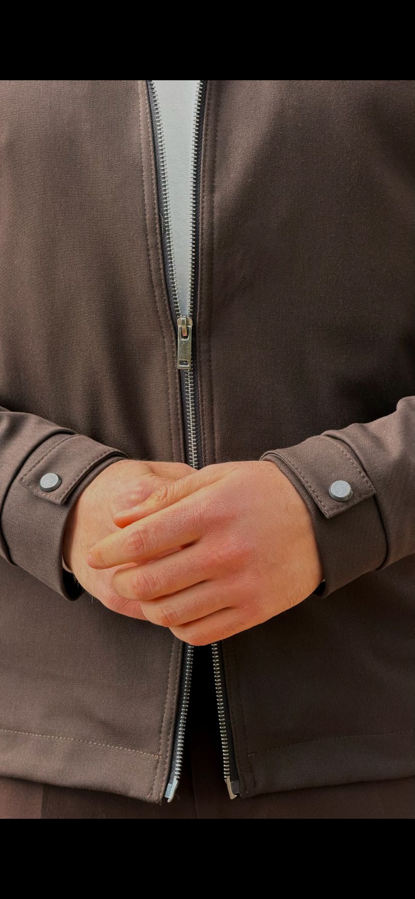 Men’s brown zip-up jacket with tailored fit and minimalist design, smart casual outerwear styled with matching trousers