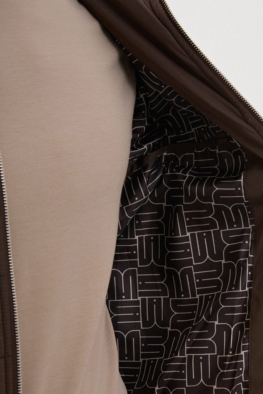 Brown men's casual jacket styled with a neutral top and dark trousers.