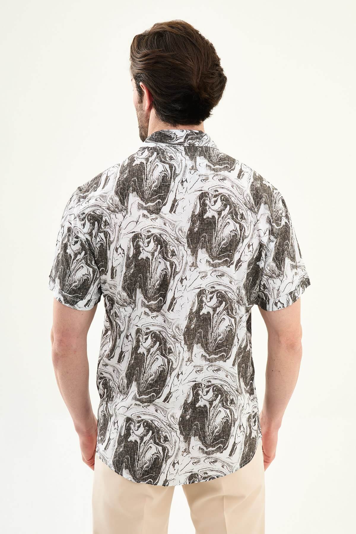 Men’s brown marble print short sleeve summer shirt with abstract pattern, styled with beige trousers for a modern casual look.