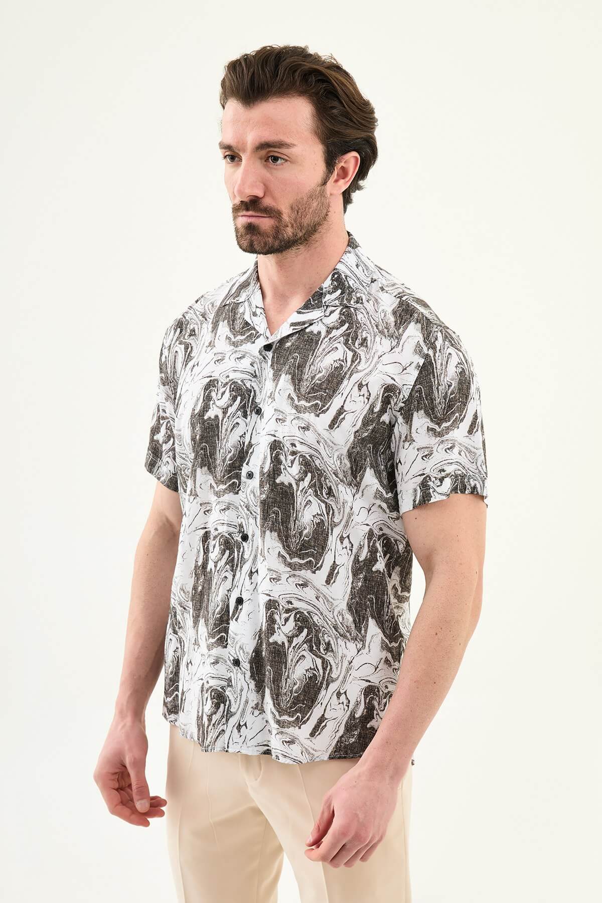 Men’s brown marble print short sleeve summer shirt with abstract pattern, styled with beige trousers for a modern casual look.