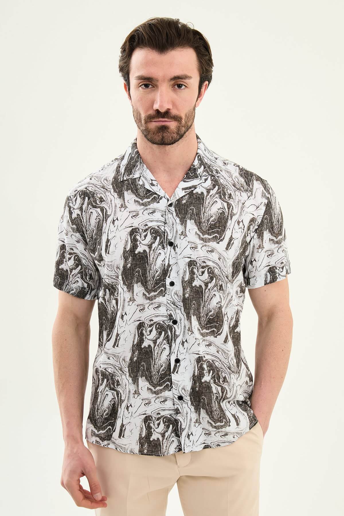 Men’s brown marble print short sleeve summer shirt with abstract pattern, styled with beige trousers for a modern casual look.