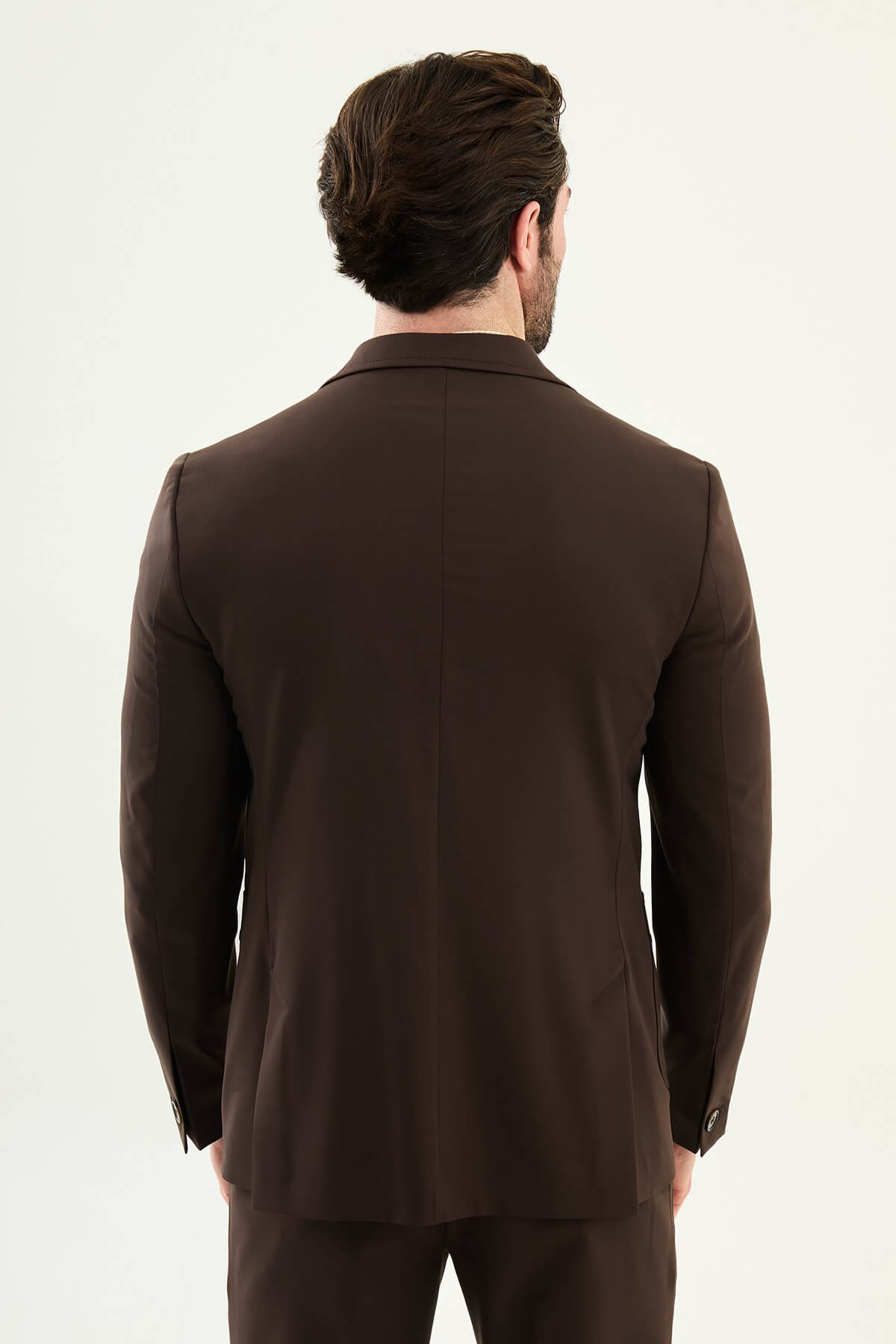 Men’s brown slim fit blazer with a clean modern design and stretch fabric, styled with a beige knit top for elegant smart casual and evening looks.