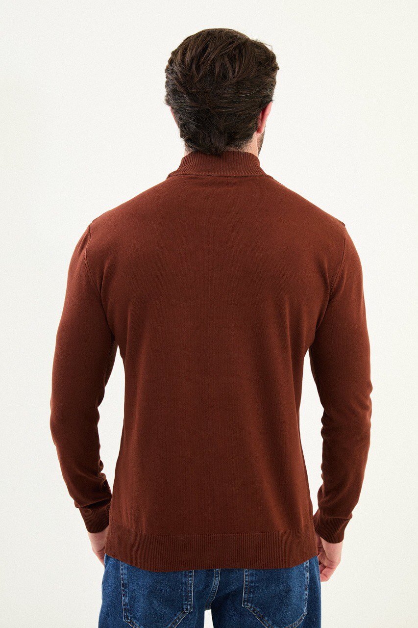 Men’s tile (terracotta) slim-fit ribbed mock-neck cotton-blend sweater with multi-directional ribbing and diagonal chest panels, styled with blue denim.