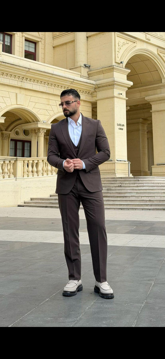 Men wearing a brown shawl lapel slim-fit suit with matching vest and trousers, styled formally for outdoor wedding or business event
