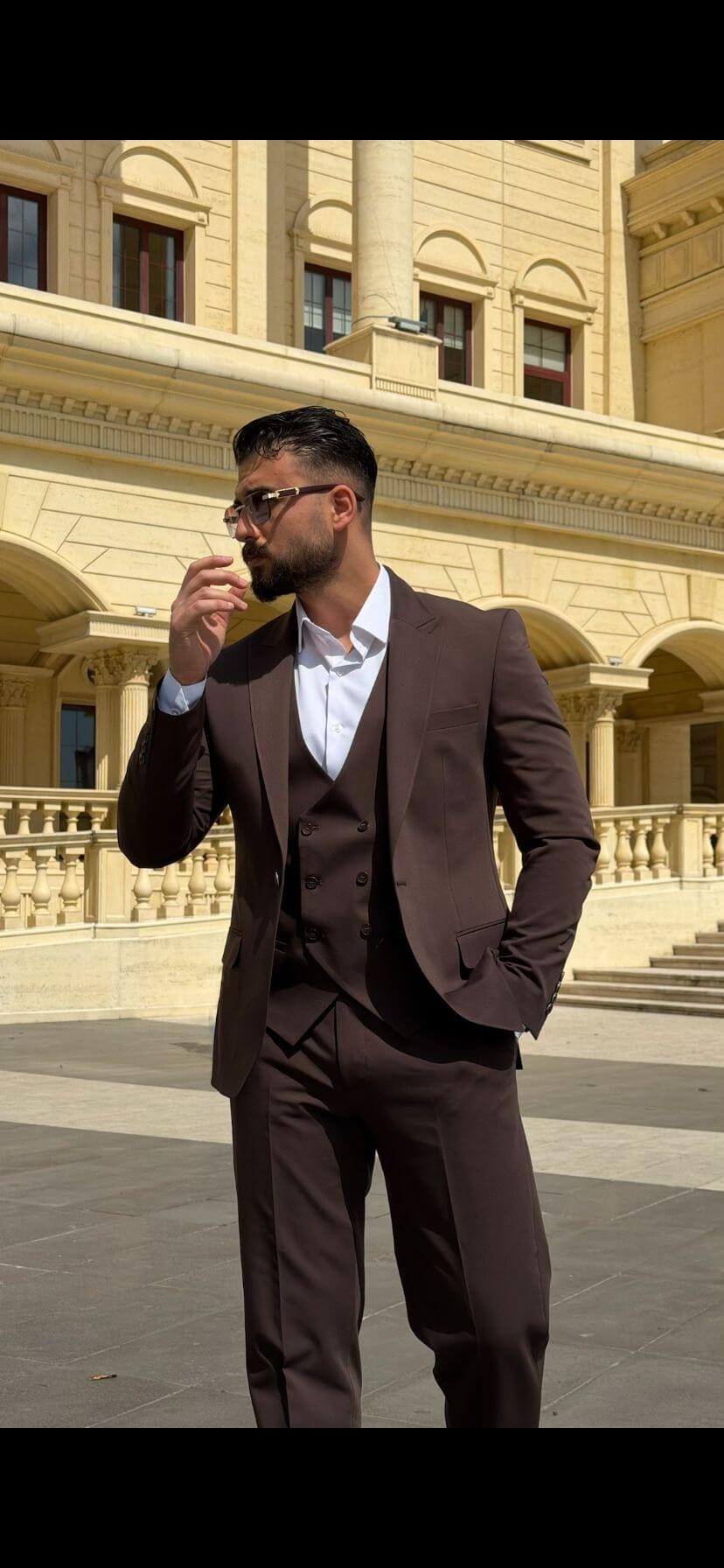 Men wearing a brown shawl lapel slim-fit suit with matching vest and trousers, styled formally for outdoor wedding or business event