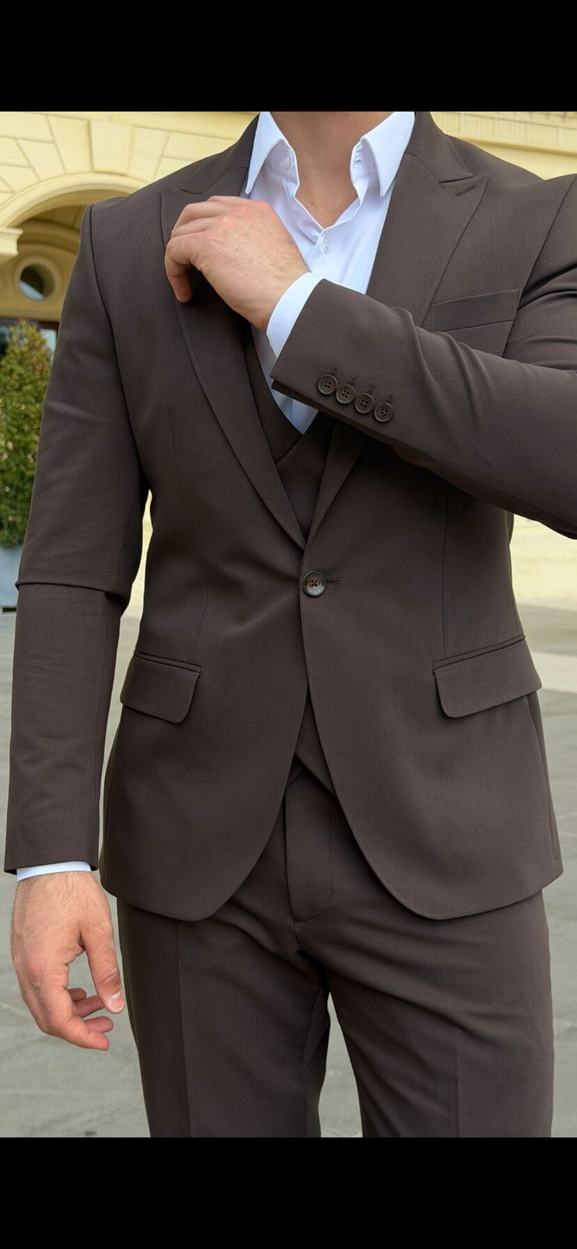 Men wearing a brown shawl lapel slim-fit suit with matching vest and trousers, styled formally for outdoor wedding or business event