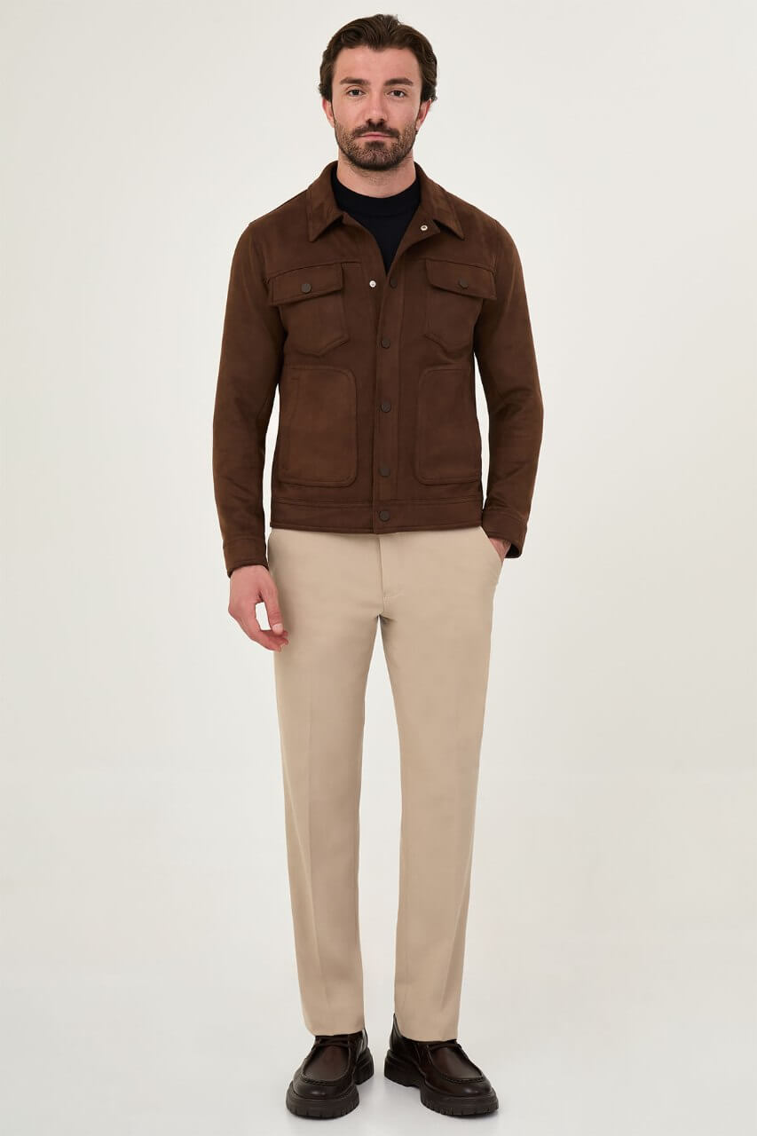 Men's brown suede-style jacket paired with a black sweater and beige trousers.