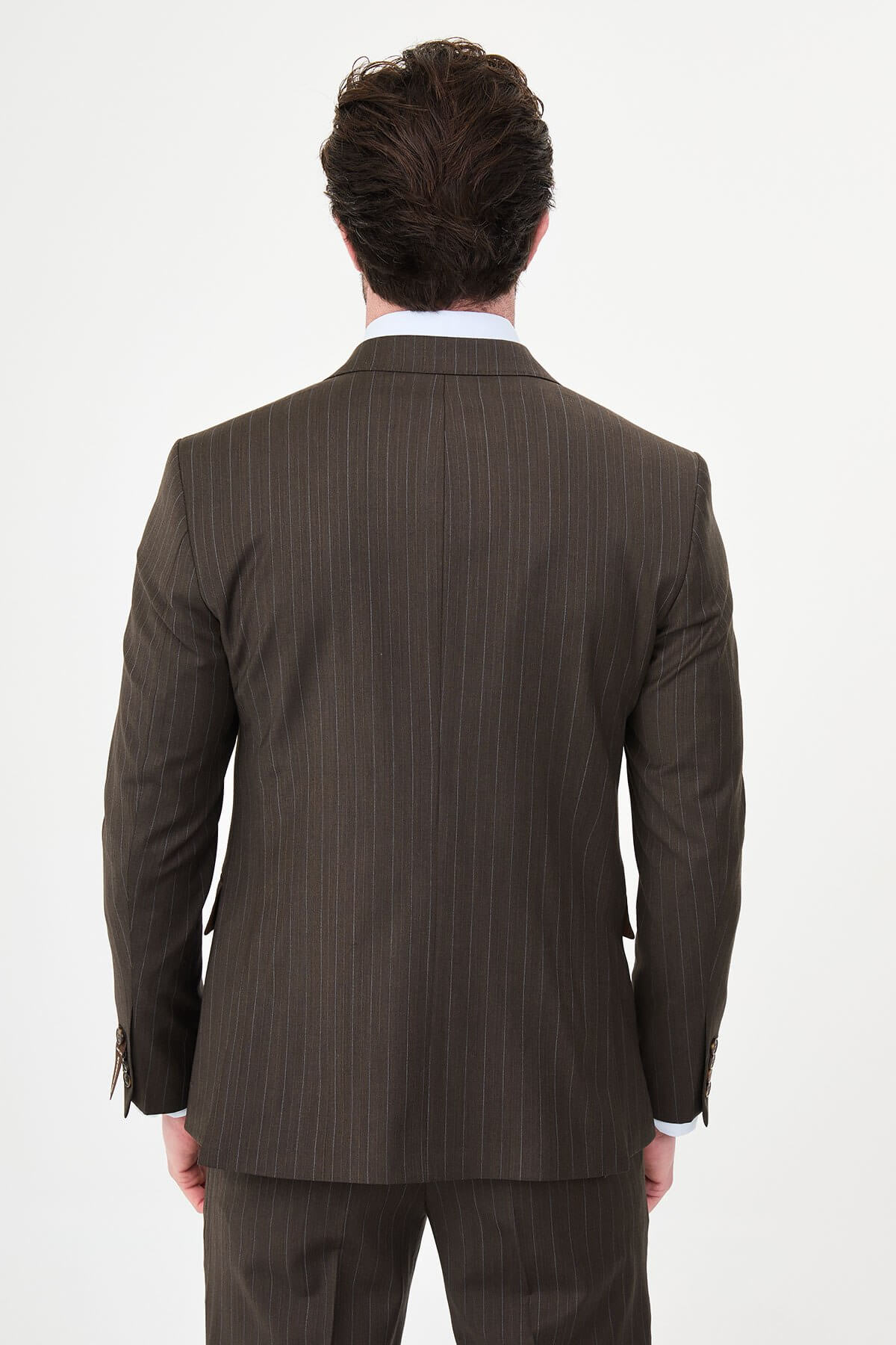 man dressed in a brown double-breasted premium wool suit with matching trousers and brown shoes