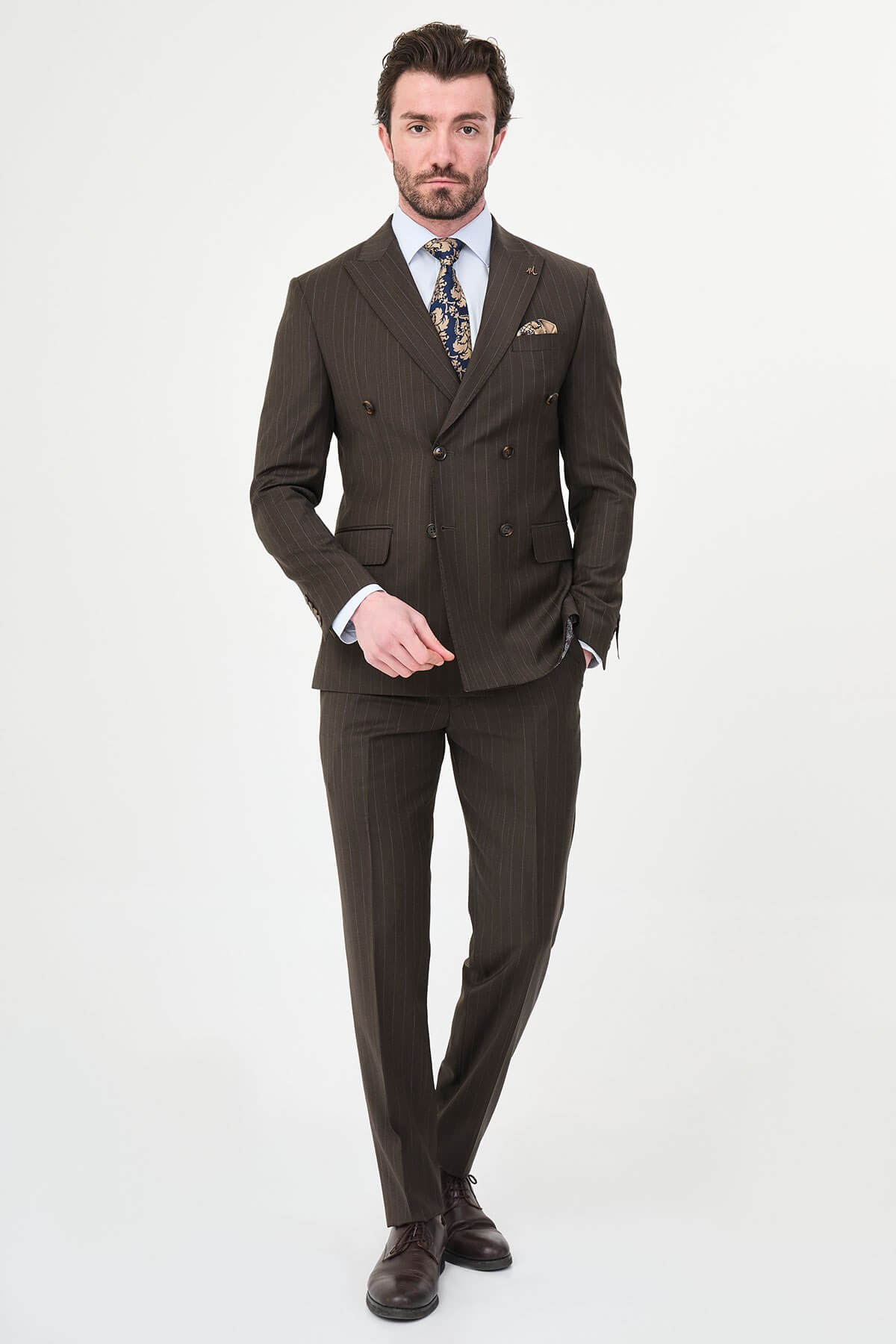 man dressed in a brown double-breasted premium wool suit with matching trousers and brown shoes