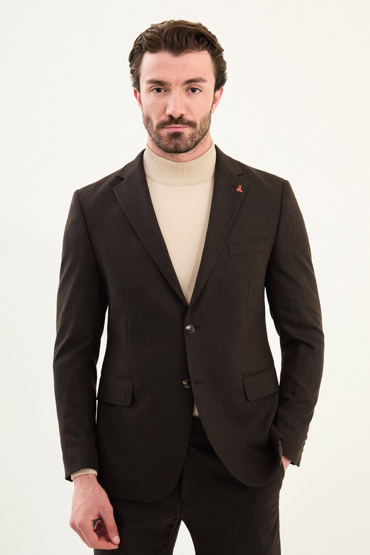 Men’s deep brown slim-fit single-breasted wool-blend suit with notch lapels and matte finish, high-wool fabric with stretch for winter wear, styled with a cream turtleneck for tonal dressing.