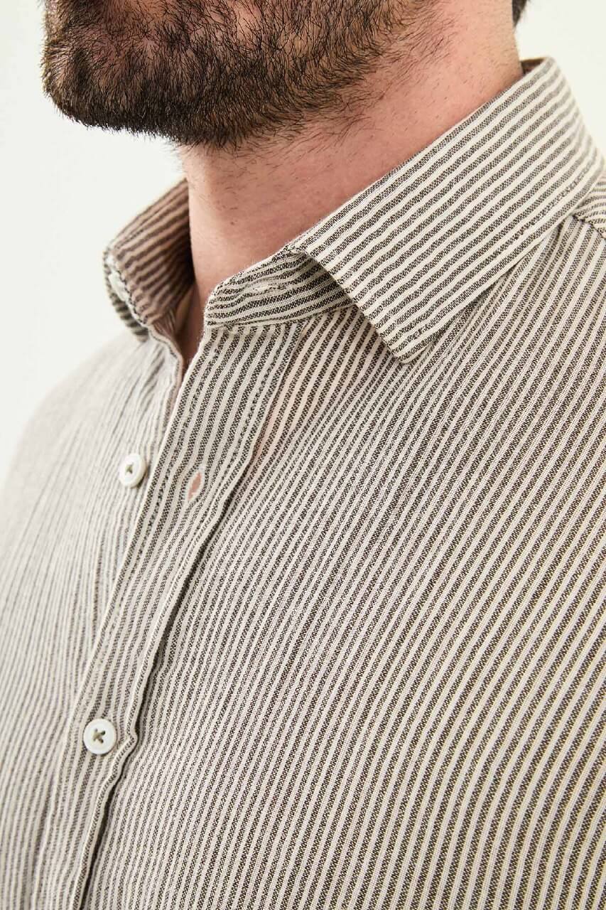 Men wearing a brown slim-fit long sleeve cotton shirt with a chest pocket, standing casually, showcasing the tailored fit and fabric texture.